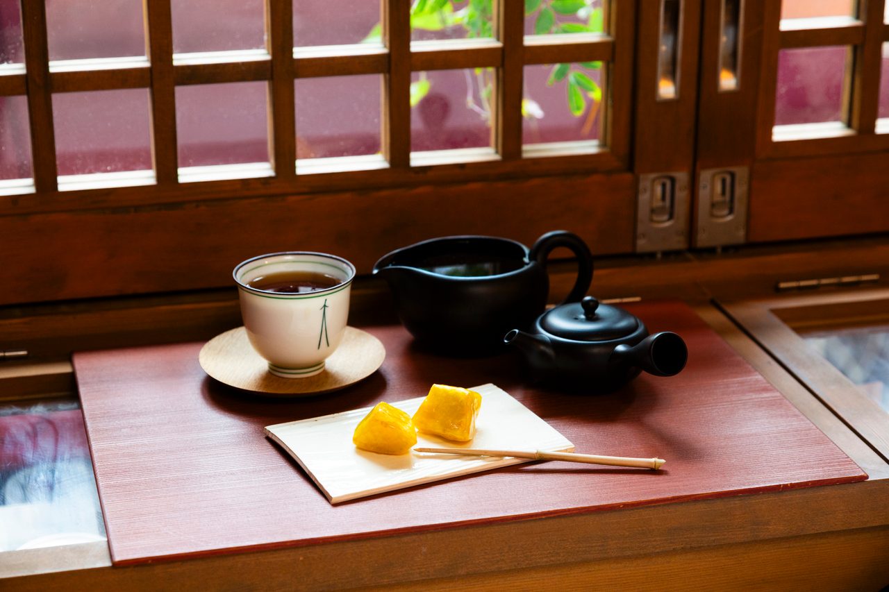 格子窓のそばの盆に、懐紙にのせた神戸あめいもが二粒。湯呑みと急須が添えられている